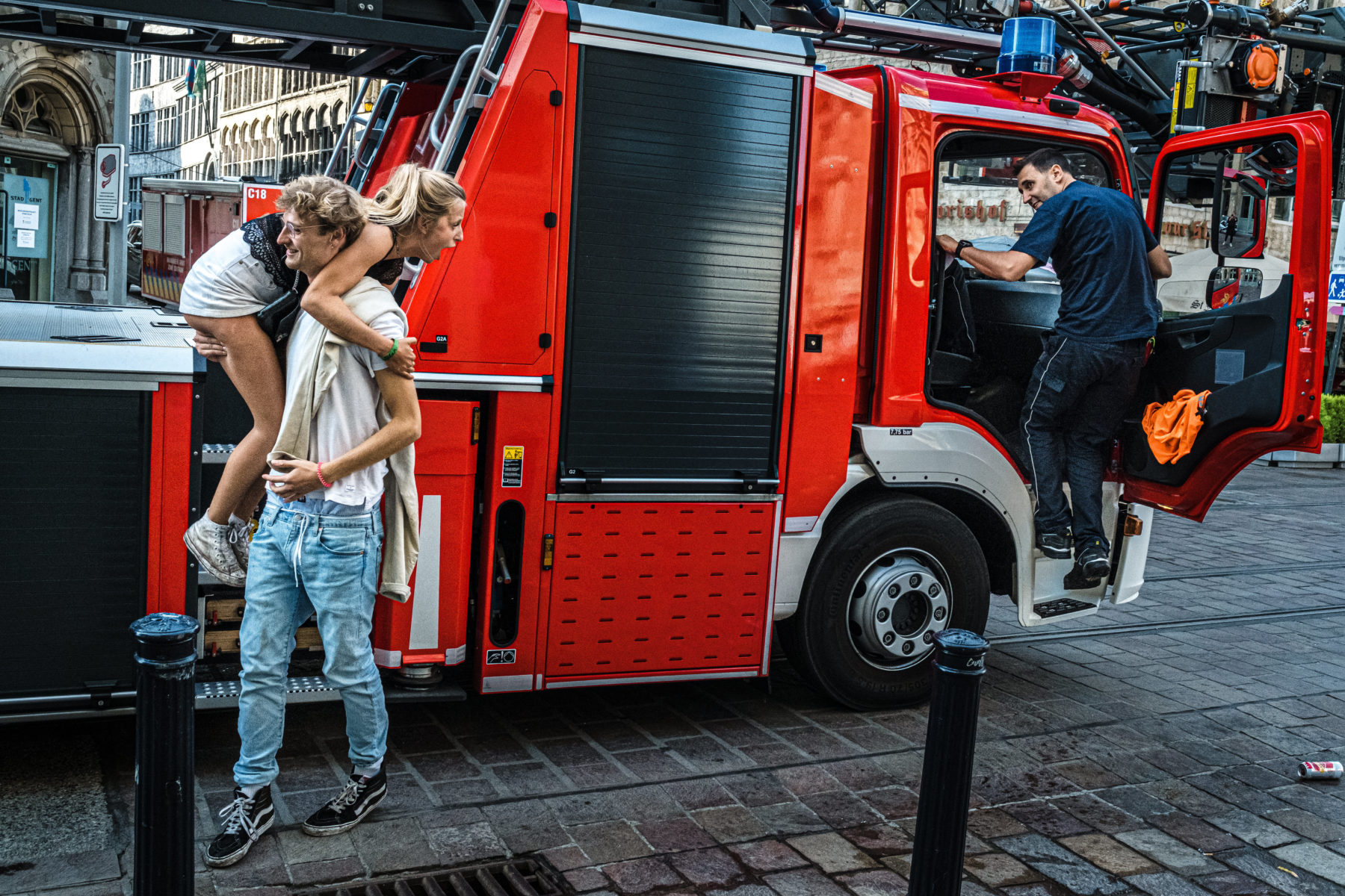 jongen draagt meisje van brandweerwagen